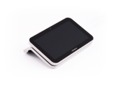 A black and white rectangular electronic device with a touchscreen is angled slightly to the side, displaying a blank screen.