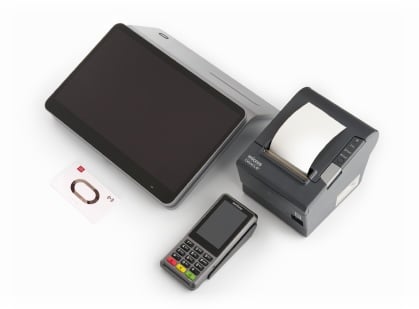 A tablet, a receipt printer, a payment terminal, and a card with a chip are arranged side by side on a white surface.