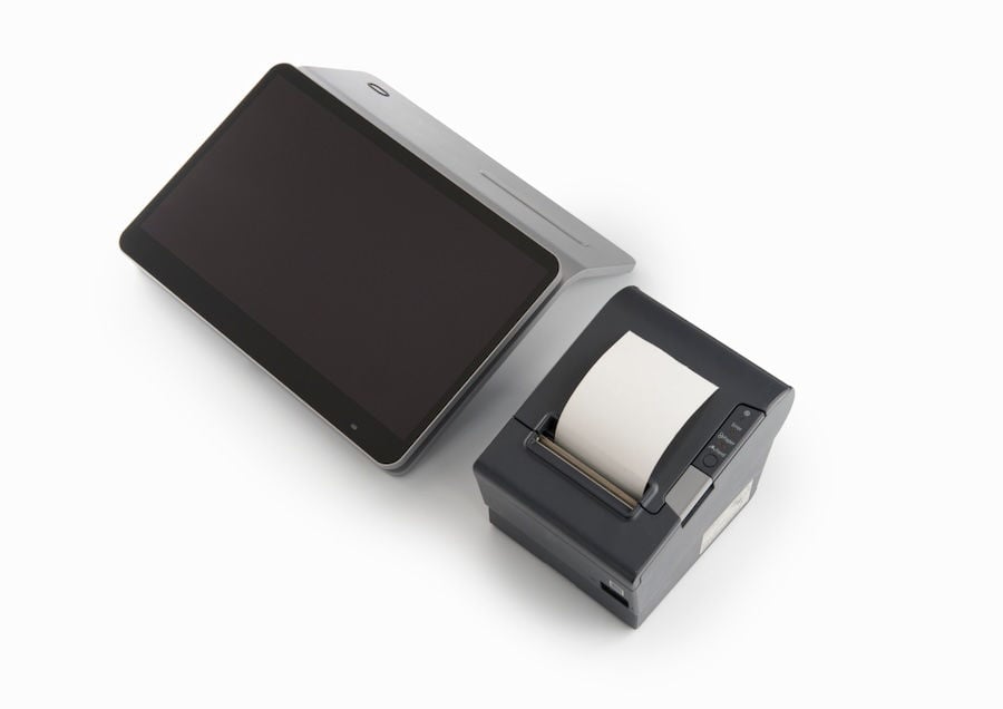 A touchscreen tablet is placed next to a compact receipt printer. Both devices are on a plain white background.